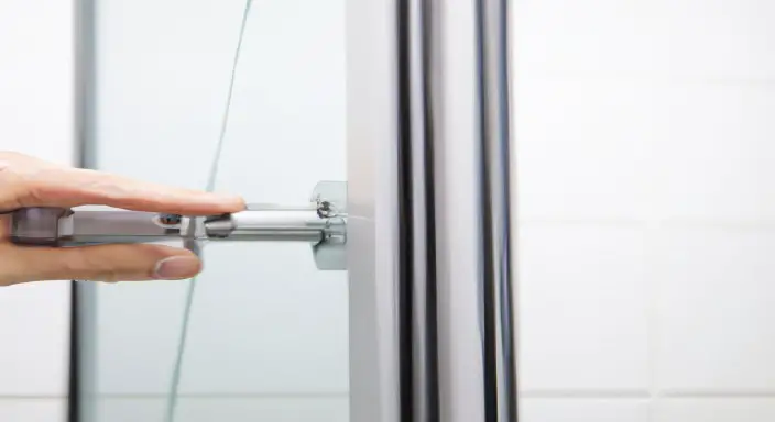 Adjust the door sweep of the glass shower door.