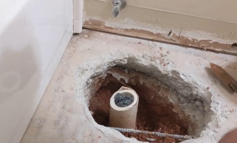 Drill a hole in the basement ceiling directly above the toilet for the vent pipe.