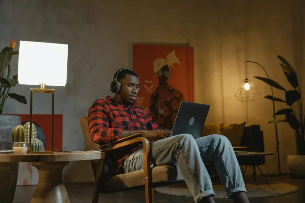African American man working on a laptop indoors, embracing remote work lifestyle.