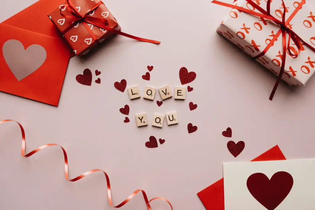 A romantic flat lay with gifts, cards, and love-themed decorations for Valentine's Day.